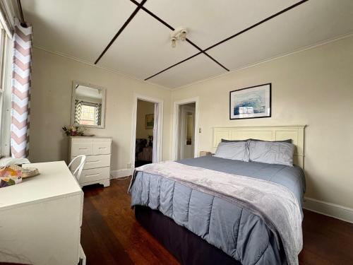 a bedroom with a bed and a dresser and a table at The Wadsworth Suite A2 in Hartford