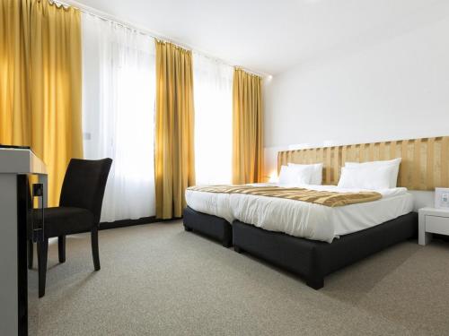 a bedroom with a bed and a chair and window at Nova City Garni Hotel Signature Collection in Belgrade