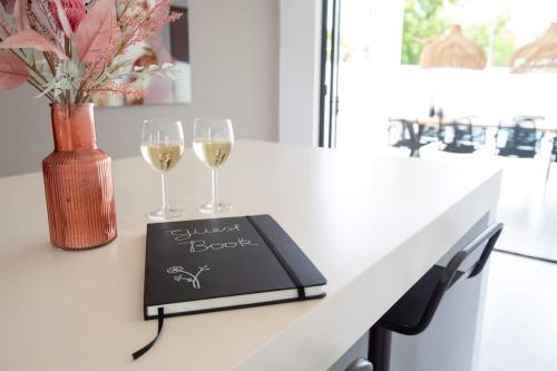 a table with two wine glasses and a book at Casa Familia in Grote Berg