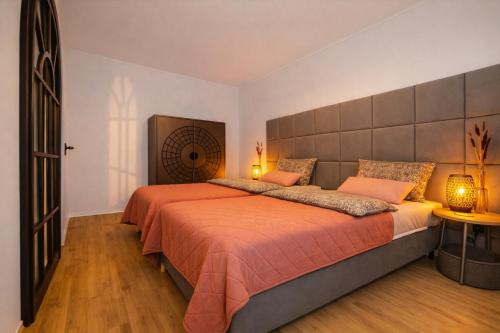 a bedroom with a large bed with orange sheets at 21 Gramm Das Verborgene mit Tiefgarage in Sasbachwalden