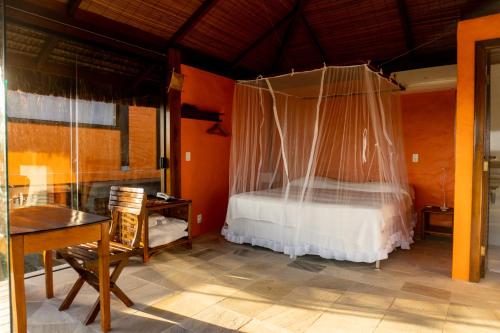 a bedroom with a bed with a mosquito net at Alizées Moreré in Ilha de Boipeba