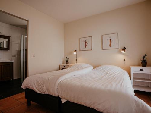 a bedroom with a large bed with white sheets at Apartment Westergeest 2 by Interhome in Uitgeest