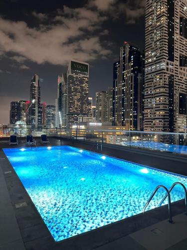 a swimming pool with a city skyline at night at Prime Apartments Near WTC and Sheikh Zayed RD in Dubai