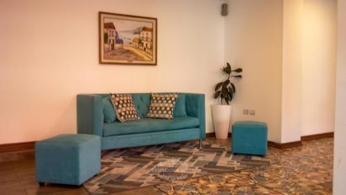 a living room with a green couch and two blue stools at Resplendor Hotel in Viña del Mar