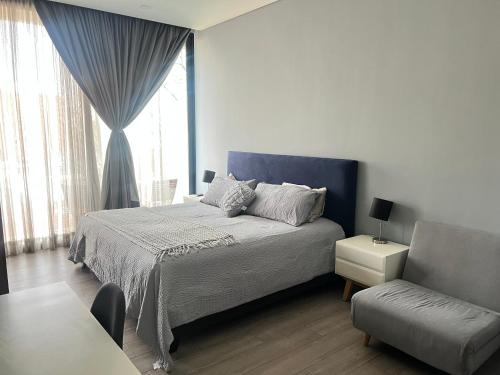a bedroom with a bed and a chair and a window at Suite en Ciudad de México céntrico in Mexico City