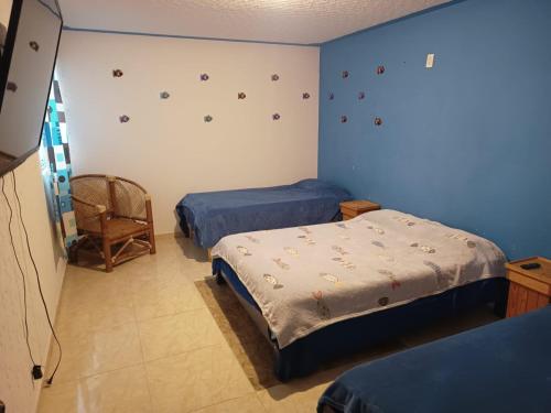 a bedroom with two beds and a chair in it at Luxos Casa Residencial Privada in San Miguel Contla
