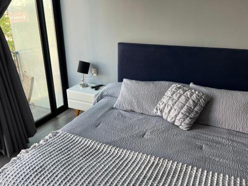 a bed with a blue headboard and a pillow on it at Suite en Ciudad de México céntrico in Mexico City
