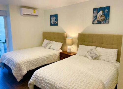 a bedroom with two beds and a lamp on a table at SKY INN Oficial Acapulco Suites & Condo Mediterrane in Acapulco