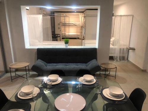 a living room with a black couch and a glass table at SKY INN Oficial Acapulco Suites & Condo Mediterrane in Acapulco
