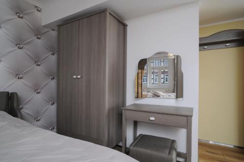 a bedroom with a bed and a desk and a cabinet at Designpension Idyll Nr2 Hotel Garni in Wernigerode