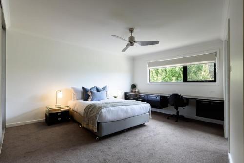 a bedroom with a bed and a desk and a window at Modern Newnham Retreat in Newnham