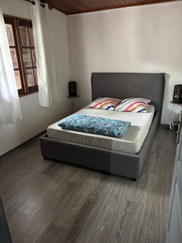 a bed in a bedroom with a wooden floor at Ti caze Montplaisir 2 in Saint-Louis