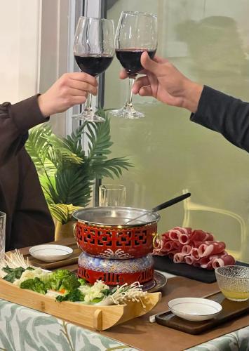 Zwei Personen halten Weingläser an einem Tisch mit Essen hoch in der Unterkunft Auberge Hotel Spa Watel in Sainte-Agathe-des-Monts