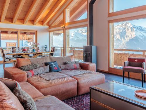 a living room with a couch and a view of a mountain at Chalet Chalet Flocon de Neige by Interhome in Nendaz