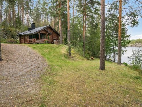 a log cabin in the woods next to a dirt road at Holiday Home Salmela by Interhome in Ollila