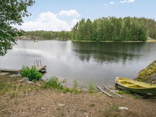 a boat sitting on the shore of a lake at Holiday Home Salmela by Interhome in Ollila