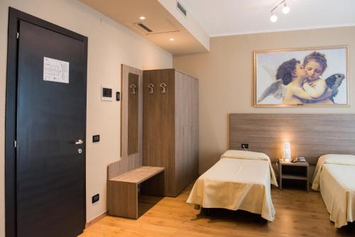 a hotel room with a bed and a table and a door at Albergo Grappolo D'oro in Montebelluna