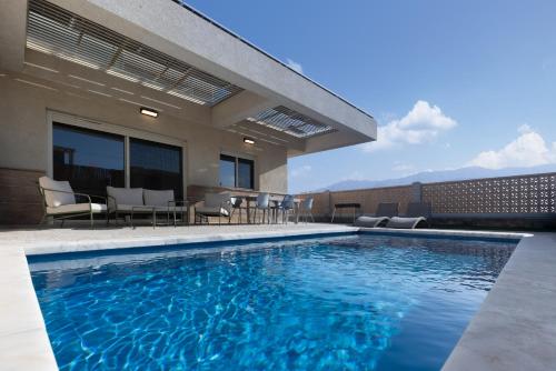 a swimming pool with chairs and a house at וילה פאן 4 חדרי שינה בריכה מחוממת Villa Fun 4 BR Heated Pool in Eilat