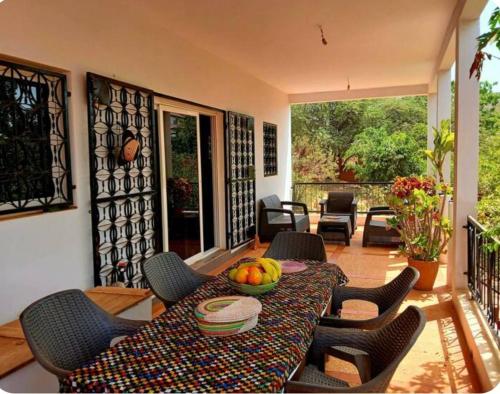 a table with a bowl of fruit on a patio at Villa AfricaSolly in Poponguine