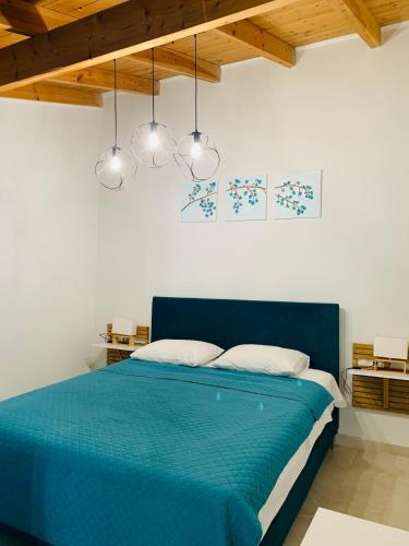 a blue bed in a white room with lights at Vita vi in Afionas