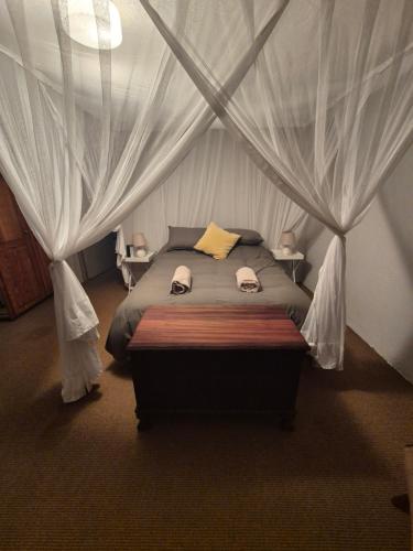 a bedroom with a bed with a canopy at The Macadamia Nut Farm House in White River