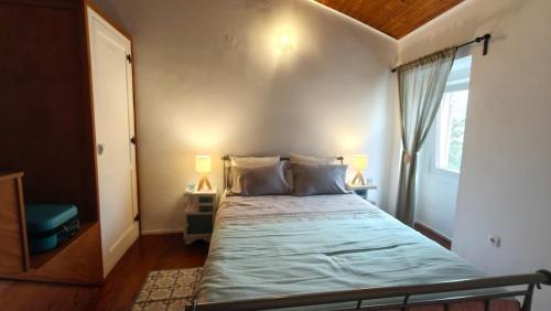 a bedroom with a bed with two lamps and a window at Alentejo Colours Avis in Avis