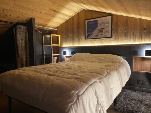 a bedroom with a large bed with a wooden ceiling at L ADRET - Duplex 6 pers 2 chambres - Belle Plagne PARADISKI in La Plagne Tarentaise