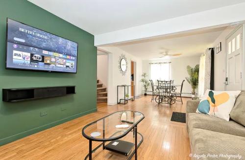 a living room with a couch and a tv on a green wall at Family Friendly 3 BR 2 BA Home near Navy Base in Waukegan