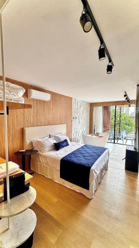 a bedroom with a bed and a tub in it at Azurine Pousada in Passo de Torres