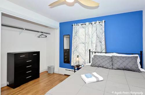 a bedroom with a bed with a blue wall at Family Friendly 3 BR 2 BA Home near Navy Base in Waukegan
