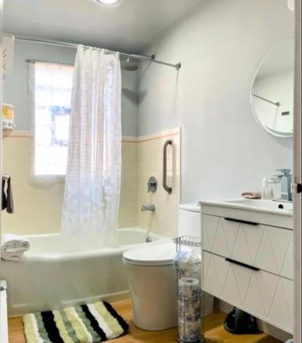 a bathroom with a tub and a toilet and a sink at Family Friendly 3 BR 2 BA Home near Navy Base in Waukegan