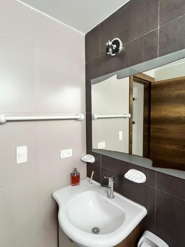 a bathroom with a sink and a mirror at Departamento frente al mar - Resort Playa Azul in Tonsupa
