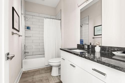 a white bathroom with a sink and a toilet at Mason Lofts at West End in Nashville