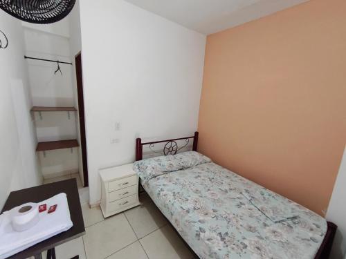 a small bedroom with a bed and a desk at Guayacan Hostel in Cali