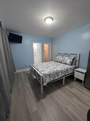 a bedroom with a bed in a room with blue walls at Cozy room close to everything, 5min to the airport in Miami