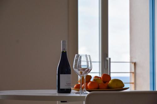 eine Flasche Wein und ein Teller mit Obst auf einem Tisch in der Unterkunft SEASIDE in Trapani