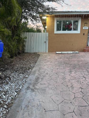 a house with a stone driveway in front of a house at Cozy room close to everything, 5min to the airport in Miami