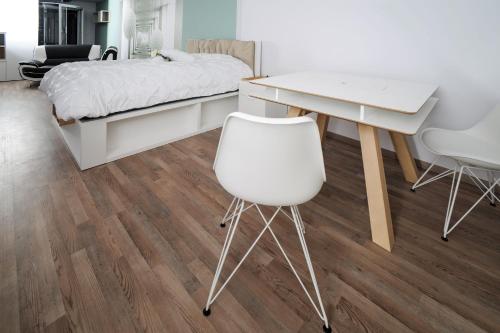 a bedroom with a desk and a bed and a white chair at Designpension Idyll Nr2 Hotel Garni in Wernigerode