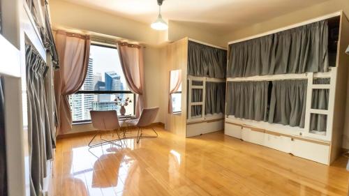 an empty living room with windows and wooden floors at Prestige holiday home Bed space in Dubai