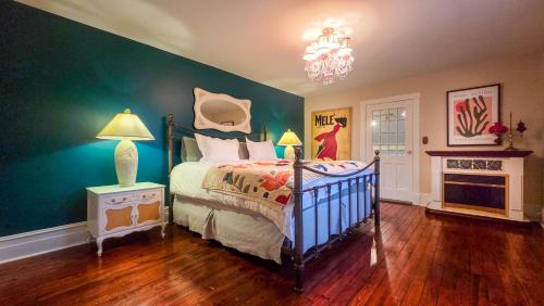 a bedroom with a bed and a green wall at The Farmhouse Manor B&B in St. Catharines