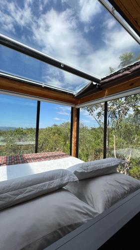 a bed in a room with a large window at Refúgio Veadeiros Container in Sao Jorge
