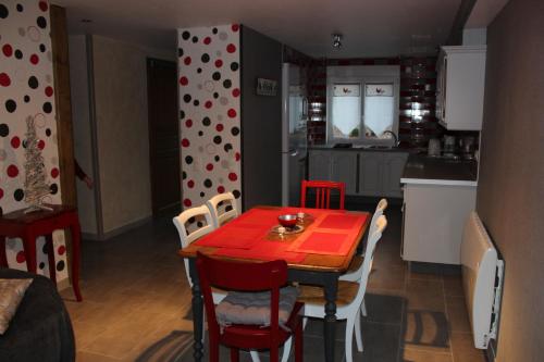 a kitchen with a dining room table with a red table cloth at Au Relais Du Canal à Grand Gabarit in Nesle