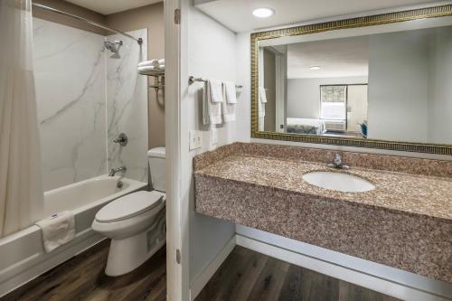 a bathroom with a sink and a toilet and a mirror at Motel 6 Greenwood, MS in Greenwood