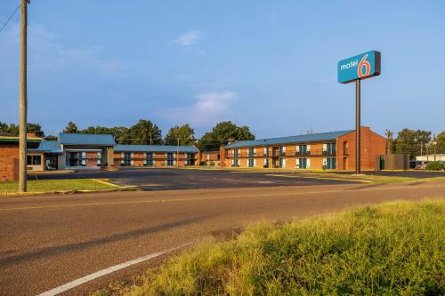 an empty road in front of a building with a street sign at Motel 6 Greenwood, MS in Greenwood