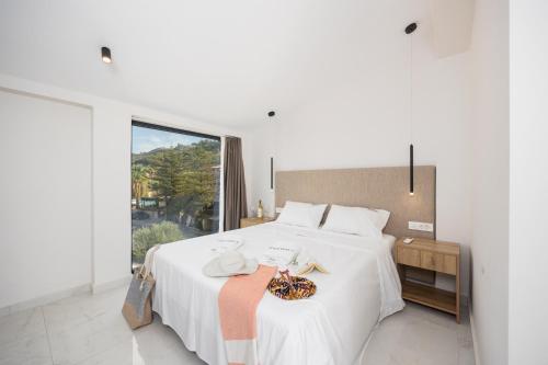 a bedroom with a large white bed with a window at Villa Infinity Ena in Kalamaki