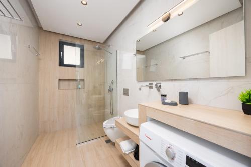 a bathroom with a shower and a toilet and a sink at Villa Infinity Ena in Kalamaki