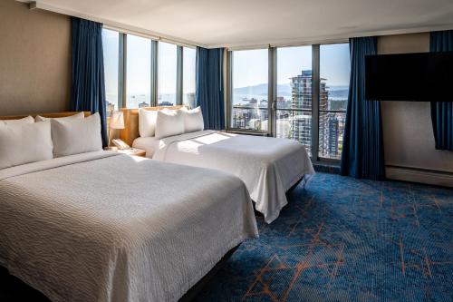 a hotel room with two beds and a large window at Blue Horizon Hotel in Vancouver