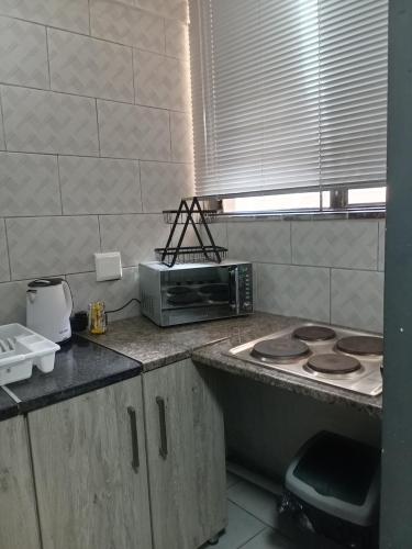 a kitchen with a toaster oven and a microwave at Comfy spacious apartment in Pretoria