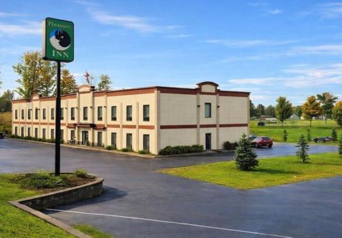 a building with a parking lot in front of it at Pleasant Night Inn Carthage Near Fort Drum in West Carthage