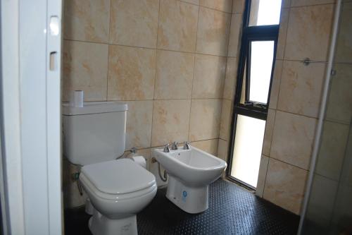 a bathroom with a toilet and a sink at Casa Tapyí Paso in Paso de la Patria